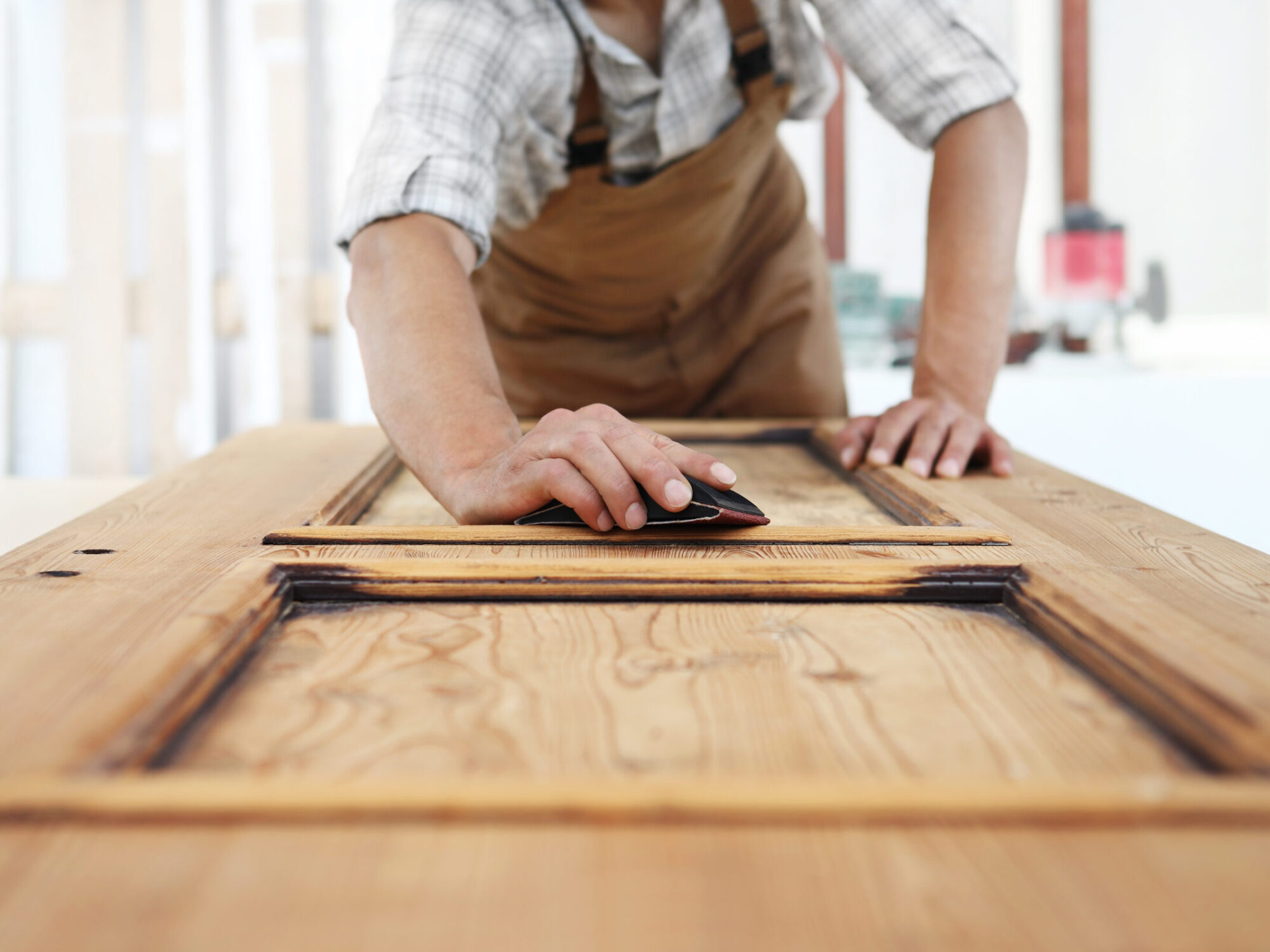 carpenter work the wood with the sandpaper